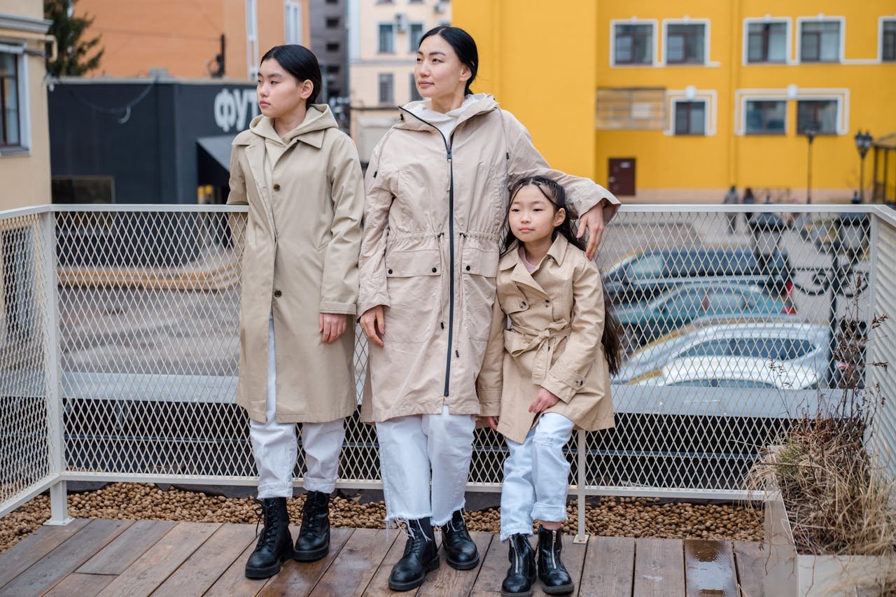 Stylish family in beige coats posing outdoors. Emphasizing fashion and unity.